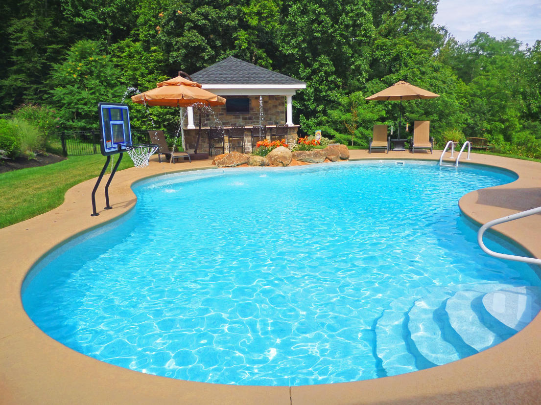 An inground swimming pool with outdoor kitchen.