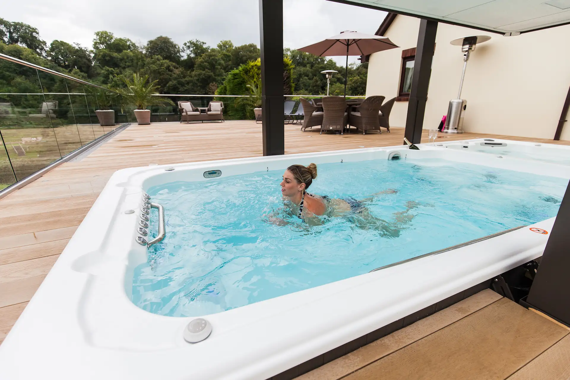 Outdoor shot of a swimmer practicing the breaststroke in a recessed swim spa.